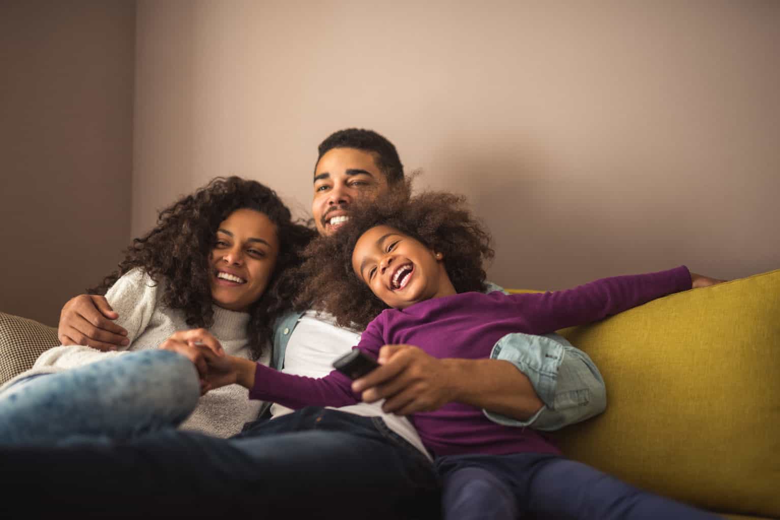 Family cuddled together on sofa